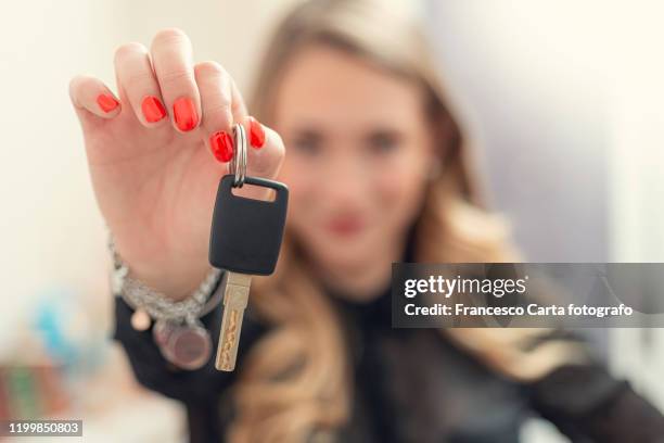 woman holding car key - car keys hand stockfoto's en -beelden
