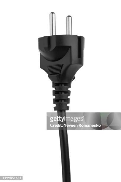 black electric plug with cable on a white background - plugging in stockfoto's en -beelden