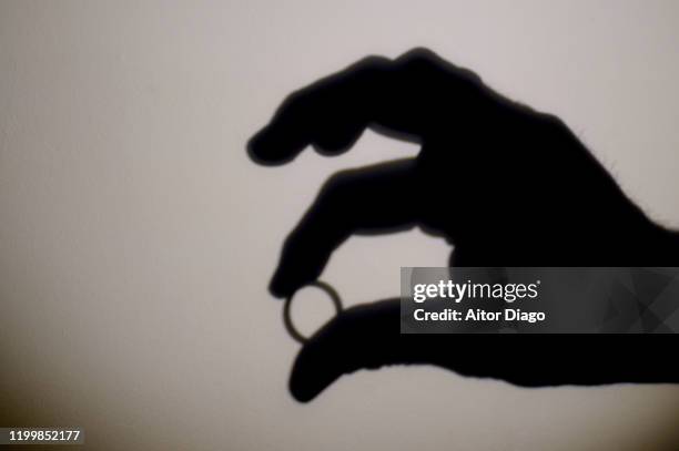 silhouette of human hand with a wedding band. - wedding symbols stock pictures, royalty-free photos & images