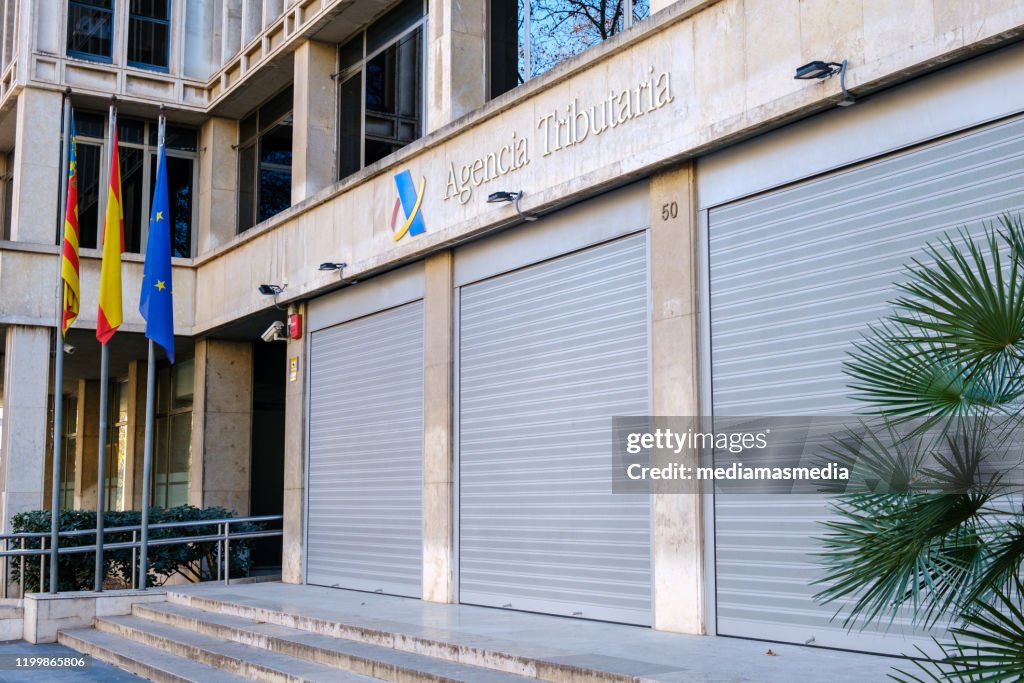 Fachada de la Sede de la Agencia Tributaria Española en Valencia, España, con puertas cerradas.