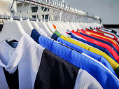 Colorful sports team shirts hanging at clothes rails