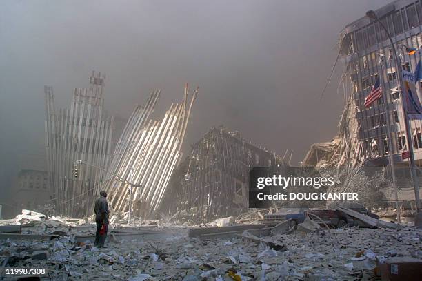 This 11 September 2001 file photo shows a man standing in the rubble, and calling out asking if anyone needs help, after the collapse of the first...