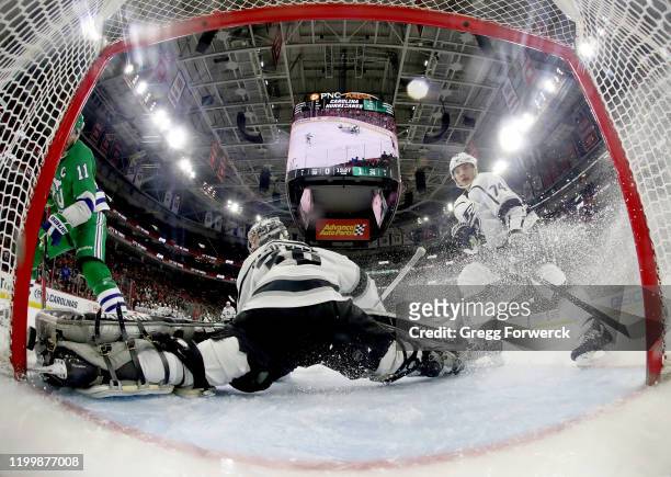 Jordan Staal of the Carolina Hurricanes attempts to backhand the puck between the pipe and the skate of Jack Campbell of the Los Angeles Kings who...