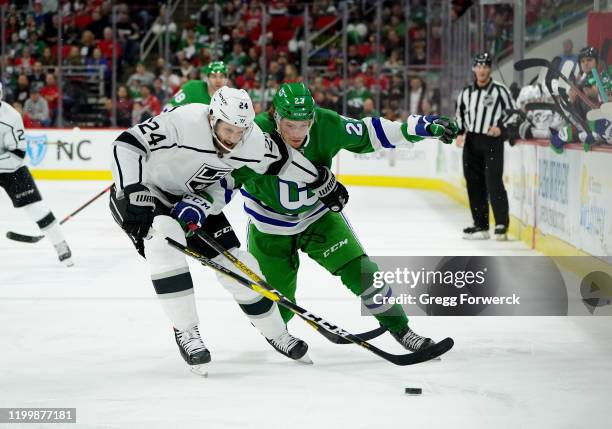 Brock McGinn of the Carolina Hurricanes battles for a loose puck with Derek Forbort of the Los Angeles Kings during an NHL game on January 11, 2020...