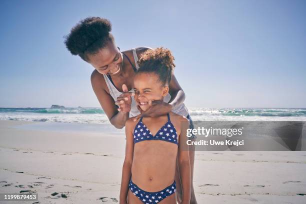 mother and daughter on beach - enfants plage photos et images de collection