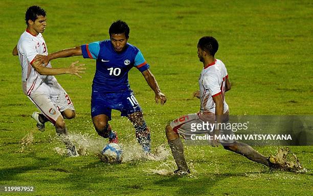 Footballers Walid Al Balooshi and Amir Mubarak tackle Jeje Lalpekhlua of India during their 2014 World Cup Asian zone Qualifying football match at...