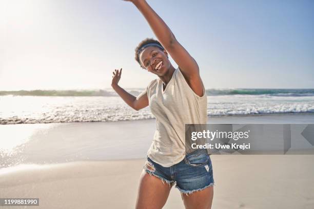 portrait of black woman on beach - ladies shorts stockfoto's en -beelden