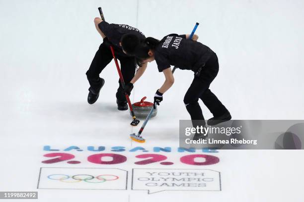 Momoha Tabata and Mina Kobayashi of Japan play a rock in their Mixed Team Finals Gold Medal match in curling against Norway during day 7 of the...