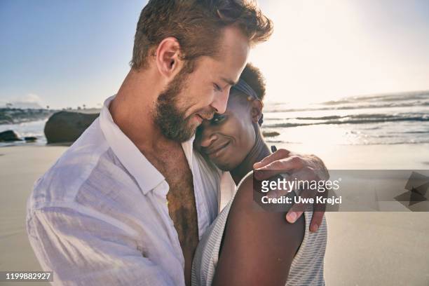 young couple embracing on beach, close-up - female hairy chest stock-fotos und bilder