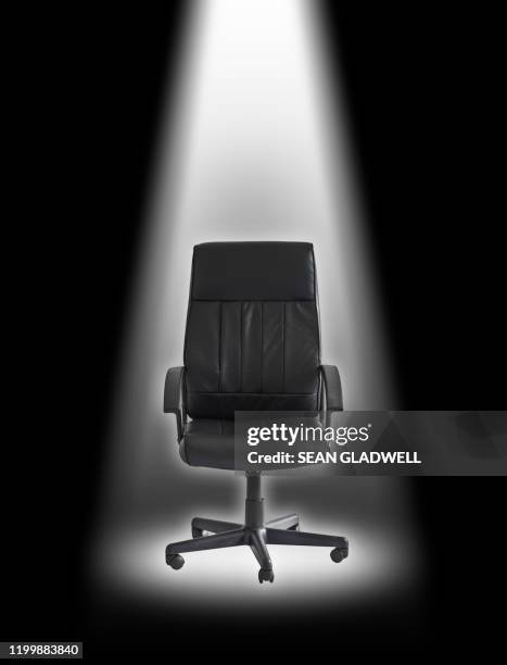 office chair under spotlight - leather office chair stock pictures, royalty-free photos & images