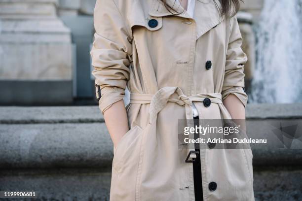 midsection of woman wearing coat - trench coat stock pictures, royalty-free photos & images