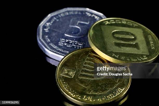israeli shekel currency on black background - israeli currency stock pictures, royalty-free photos & images