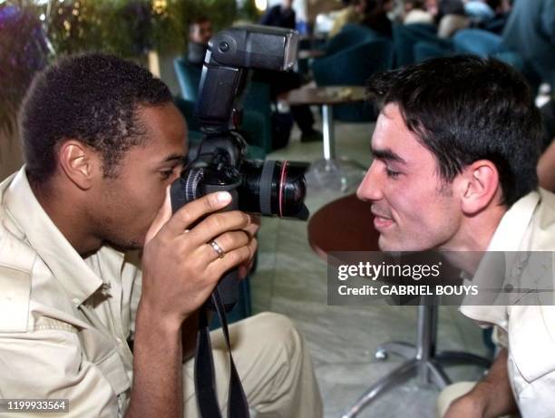 Attaquant Thierry Henry s'amuse à photographier son co-équipier Robert Pires, le 04 juin à Helsinki, peu après l'arrivée de l'équipe de France sur le...