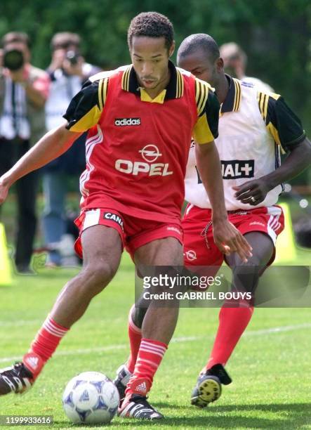 L'attaquant Thierry Henry déborde Lilian Thuram, le 22 mai, lors de l'entraînement au Centre technique du Football de Clairefontaine, où l'équipe de...