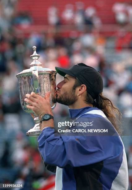 American tennis player Andre Agassi kisses the Winner's trophy after defeating German Michael Stich here 11 september 1994 during the Men's US Open...