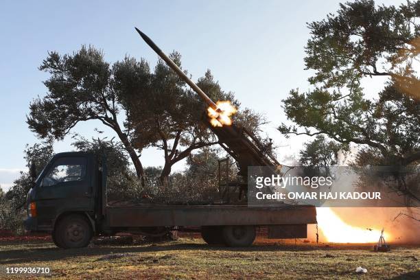 Rocket is remotely-fired from a truck-mounted launcher at a Syrian rebel fighters' position in the countryside of Idlib towards regime forces...