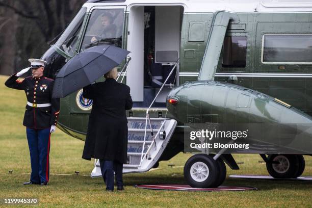 President Donald Trump holds an umbrella while boarding Marine One on the South Lawn of the White House in Washington, D.C., U.S., on Monday, Feb....