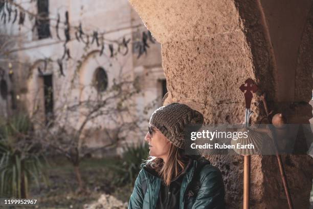 pilgrim resting near a church on the way to santiago with a hiking pole with shell. - camino de santiago stock-fotos und bilder