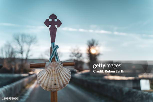 pilgrim's shell and classic stick detail view on the way to santiago de compostela - pilgrim stockfoto's en -beelden