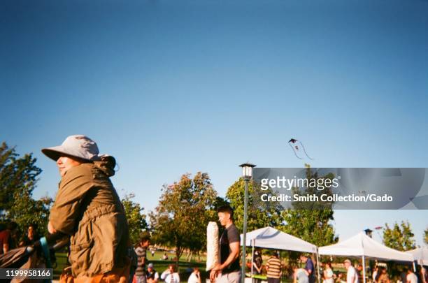People fly kites and walk past booths at a farmer's market and outdoor concert and festival in Dublin, California, 2019. Courtesy TH Productions.