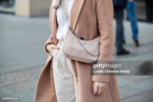 Inga Brauer is seen wearing camel coat Reserved, white oversized blouse H&M, slouchy jeans Zara, multi pochette bag Prada during the Berlin Fashion...