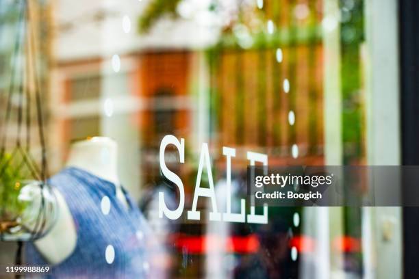 sale is on a retail display of a clothing business storefront in vancouver canada - store window stock pictures, royalty-free photos & images