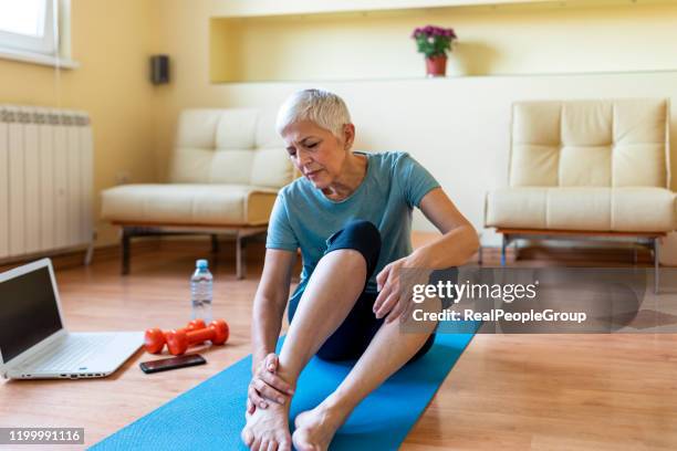 a mulher sênior tem ferimento do tornozelo - older woman legs - fotografias e filmes do acervo