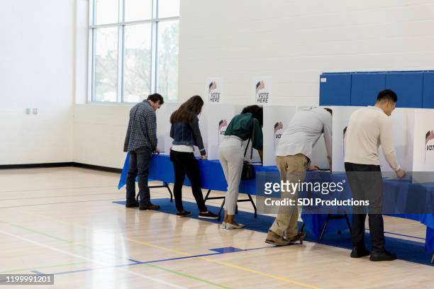 mensen staan bij stemhokjes langs de gym wall - voting booth stockfoto's en -beelden