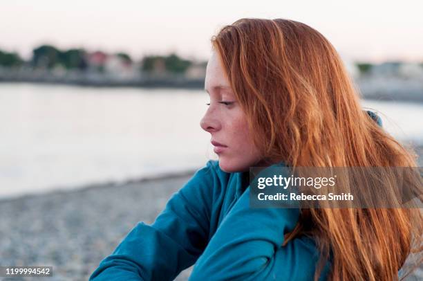 contemplative teenager at the ocean - mental illness child stock pictures, royalty-free photos & images