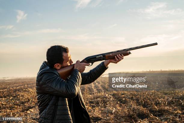 hunter posing with hunting gun - shotgun stock pictures, royalty-free photos & images