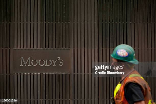 Pedestrian passes in front of the Moody's Investors Service Inc. Headquarters in New York, U.S., on Thursday, July 28, 2011. Moody's Investors...