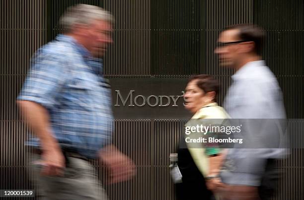 Pedestrians pass in front of the Moody's Investors Service Inc. Headquarters in New York, U.S., on Thursday, July 28, 2011. Moody's Investors...