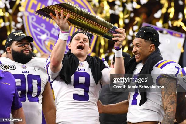 Joe Burrow of the LSU Tigers holds up the trophy after defeating the Clemson Tigers during the College Football Playoff National Championship held at...