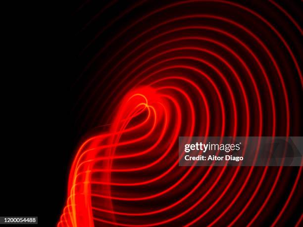 light artistic installation at night. circular red lines with black background. - reds foto e immagini stock