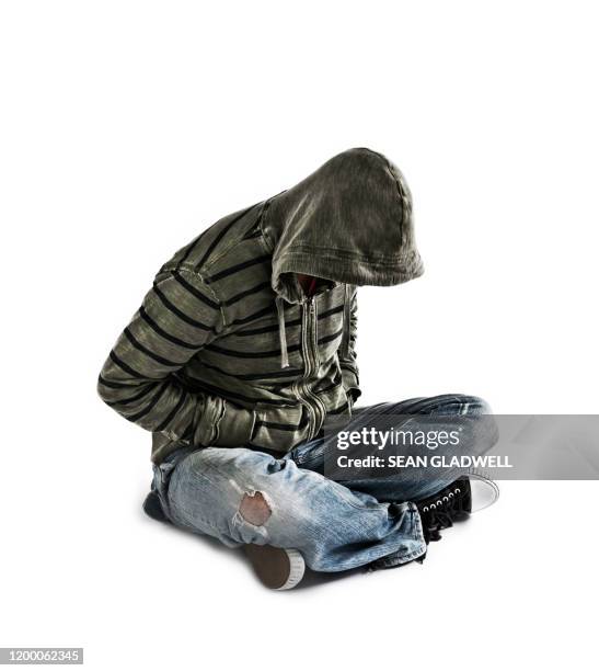 man in hoody sitting on white background - homeless man stock pictures, royalty-free photos & images