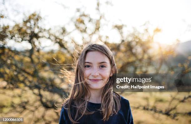 a happy small girl standing outdoors in nature in autumn. - youth portrait foto e immagini stock