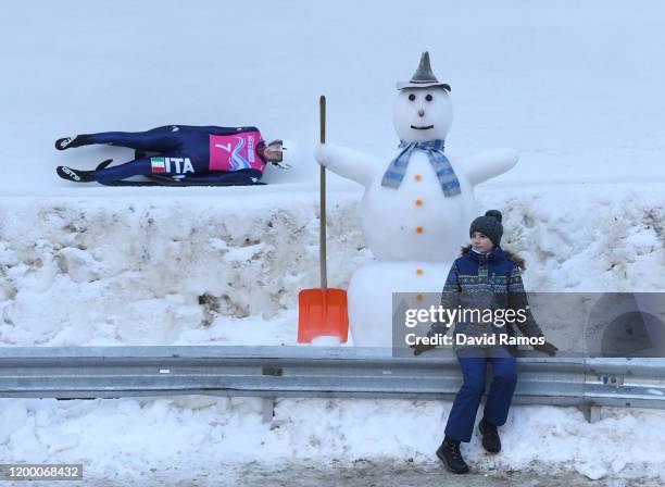 Nadia Falkensteiner of Italy competes in Women's Singles Competition second run in luge as a girl poses for a photograph during day 8 of the Lausanne...