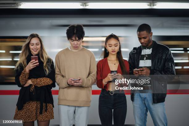 multietniska vänner som använder mobiltelefoner på subway - subway platform bildbanksfoton och bilder