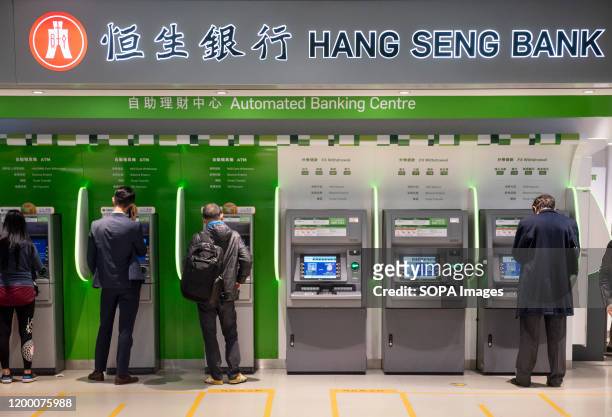Clients withdraw money from a Hang Seng Bank ATM in Central MTR subway in Hong Kong.