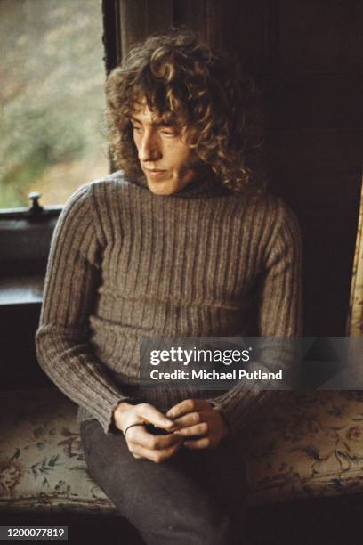 English singer Roger Daltrey of The Who relaxes on a bench seat by a window in England in 1971.