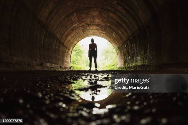 ung kvinna i slutet av en tunnel - woman body contour standing bildbanksfoton och bilder