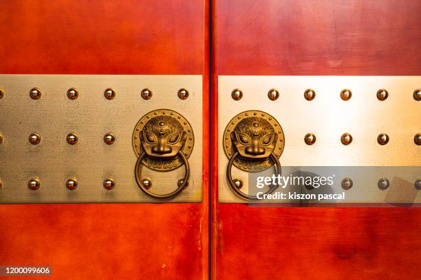 golden lion head door knocker on red door in china. - leo awards 2016 stock pictures, royalty-free photos & images