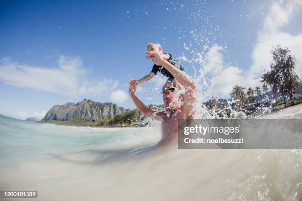 father and son playing in the ocean, hawaii, usa - hawaii fun fotografías e imágenes de stock