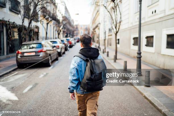 a young man walking through the city. - madrid street stock pictures, royalty-free photos & images