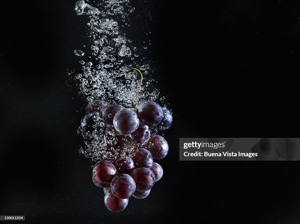 Grapes splashing in water