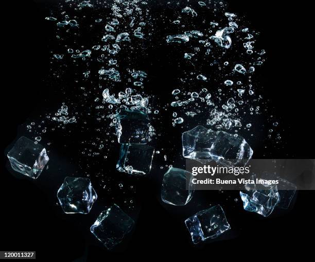 ice cubes splashing in water - cubito de hielo fotografías e imágenes de stock