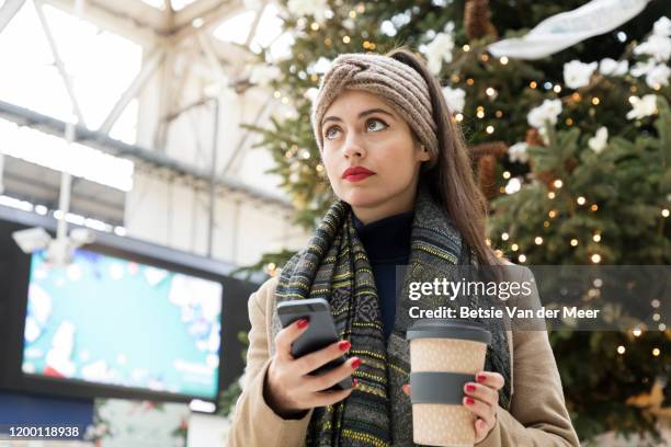 woman waiting at station looking up at departure board. - for sale frase en inglés fotografías e imágenes de stock