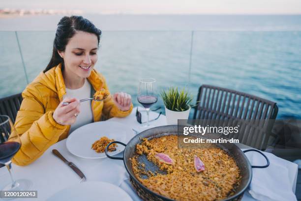 tourist eating spanish paella at the beach - waterfront dining stock pictures, royalty-free photos & images