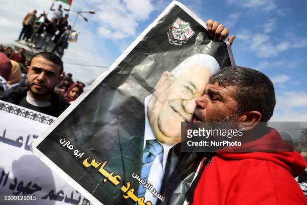 Demonstrator kisses a poster of Palestinian President Mahmoud Abbas during a rally in support of Abbas and against U.S. President Donald Trump's...