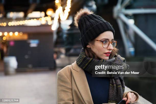 portrait of woman walking down embankment. - eyeglasses winter stock pictures, royalty-free photos & images